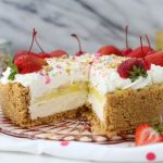 Colorful banana split pie with whipped cream and cherries in a pie dish