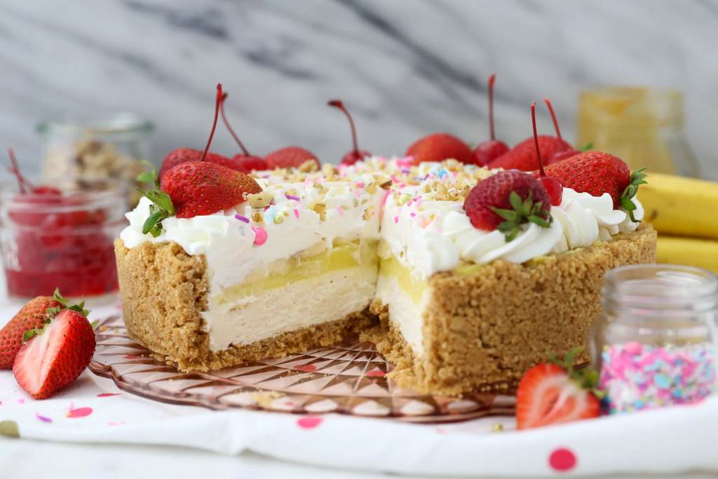 Colorful banana split pie with whipped cream and cherries in a pie dish