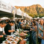 World-class chefs plating dishes with fresh Hawaiian ingredients at an outdoor grand tasting event during the Hawaii Food and Wine Festival 2026 on Oahu's Kapiolani Community College Great Lawn